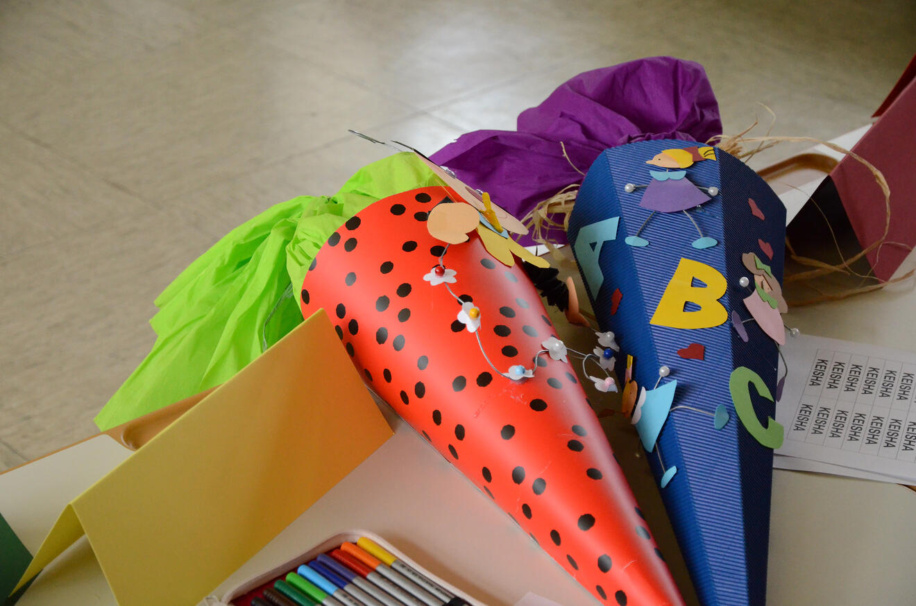 Bunte Schultüten in verschiedenen Farben und Designs auf einem Tisch, bereit für den Schulanfang.