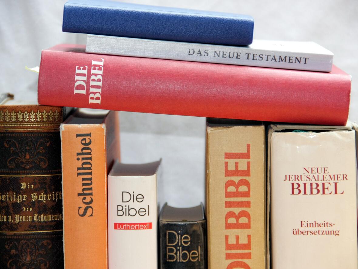 Verschiedene Ausgaben der Bibel und verwandte Texte auf einem Tisch angeordnet.